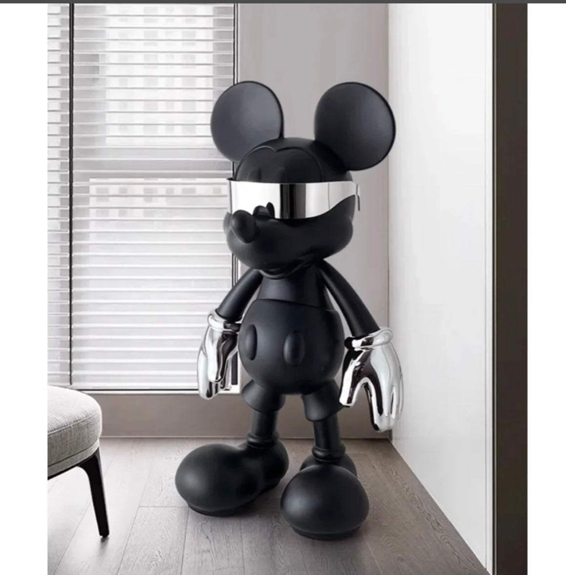 En svart, stiliserad Mickey Mouse-figur med silvriga handskar, som visar en elegant och modern design.
