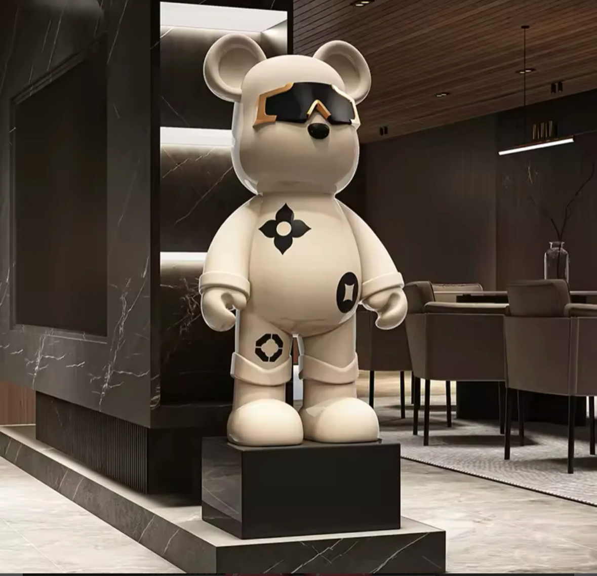 Vit Astro Bear-figur med svarta geometriska mönster och reflekterande solglasögon, placerad i en modern interiör.