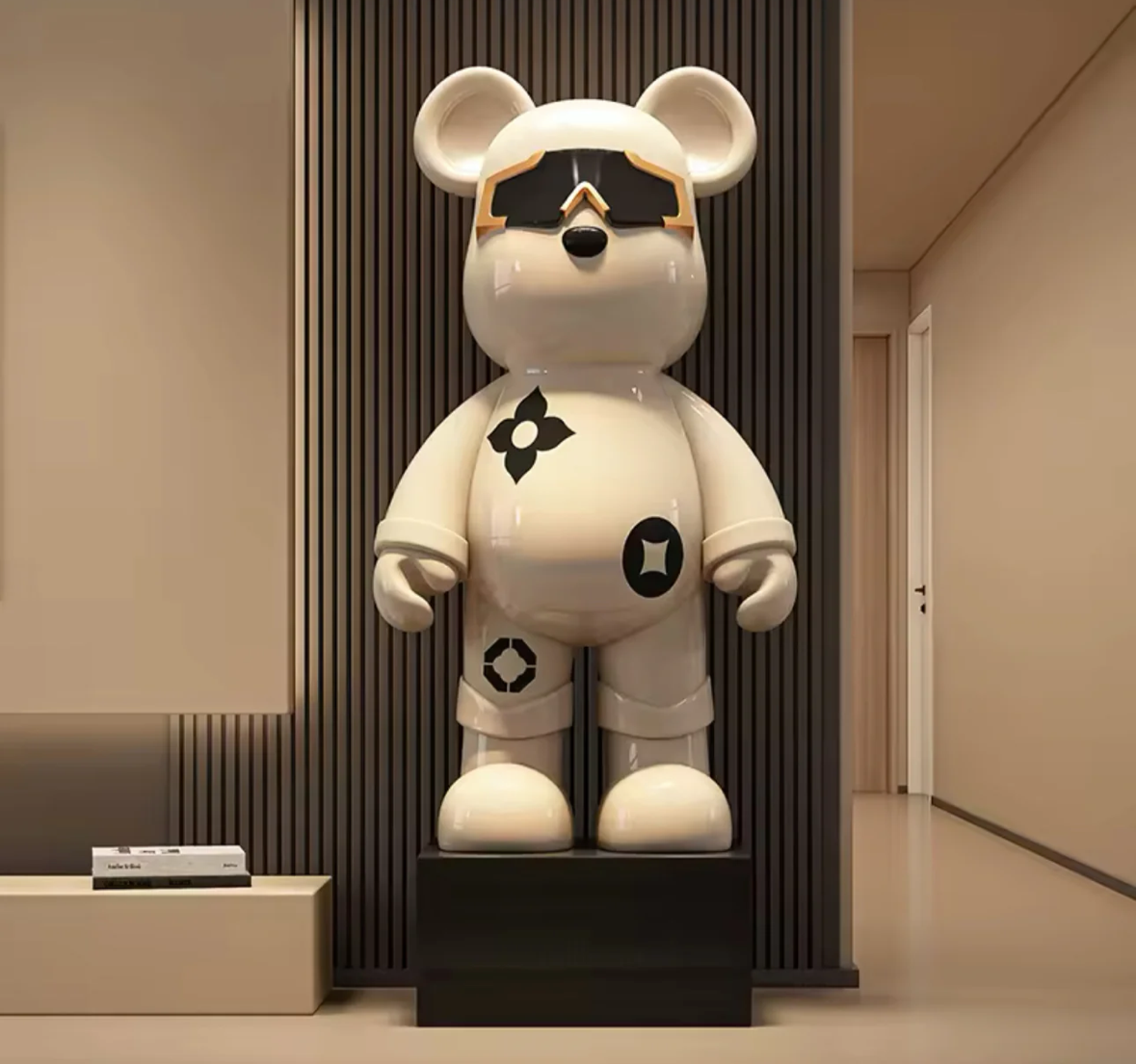 Vit Astro Bear-figur med svarta geometriska mönster och reflekterande solglasögon, placerad i en modern interiör.