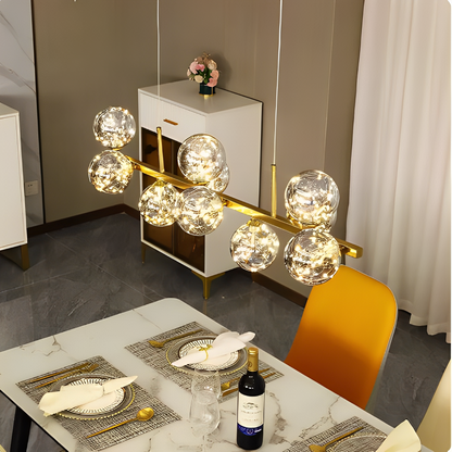 Vidvinkelvy över en matsal upplyst av elegant pendelbelysning, perfekt för middagsbjudningar.