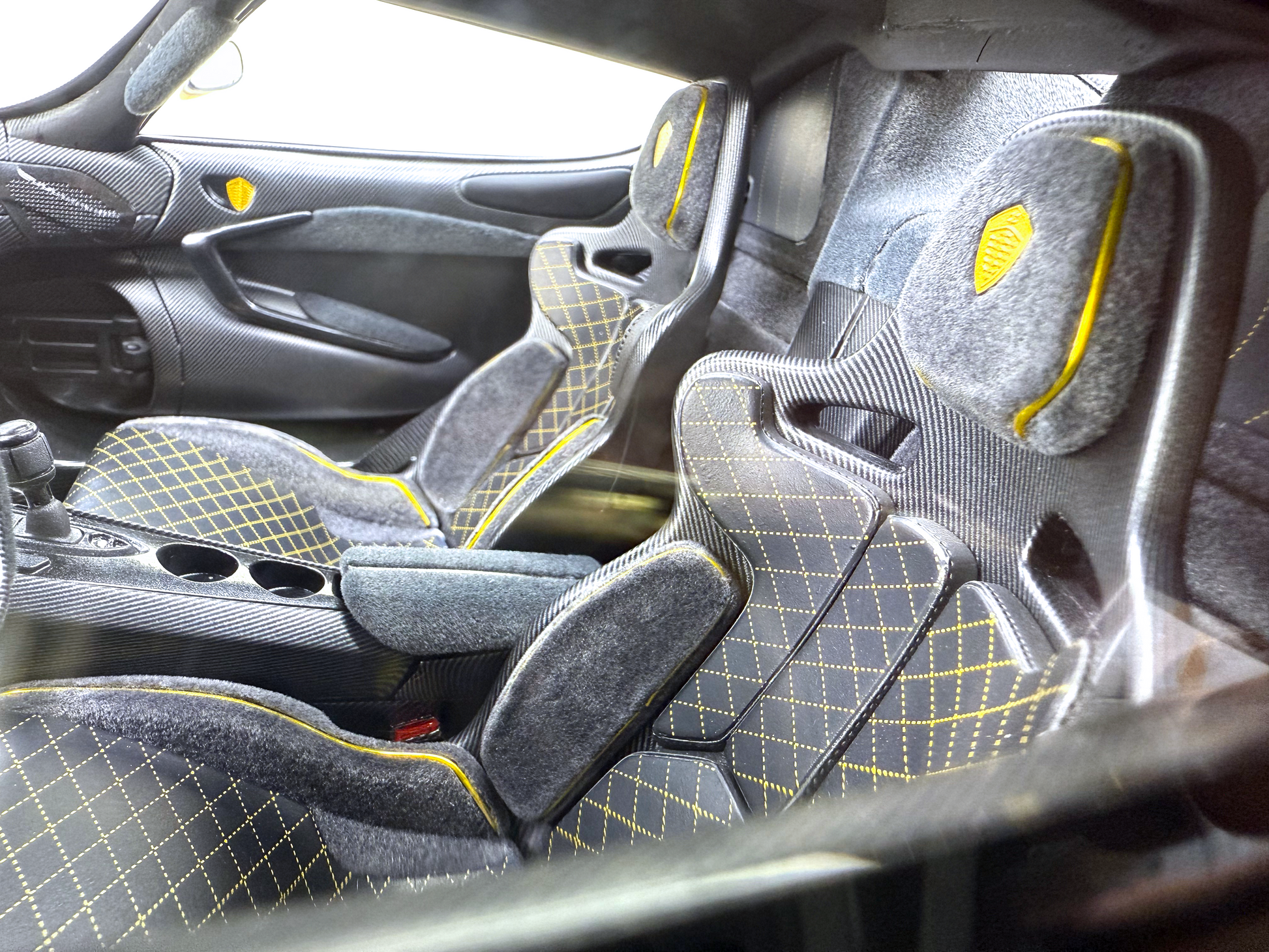 Detaljerad interiörvy av Jesko Carbon Fury Edition i skala 1:8 med exponerade kolfiberpaneler, skarp gul kontrastsöm och en minimalistisk racingcockpit.