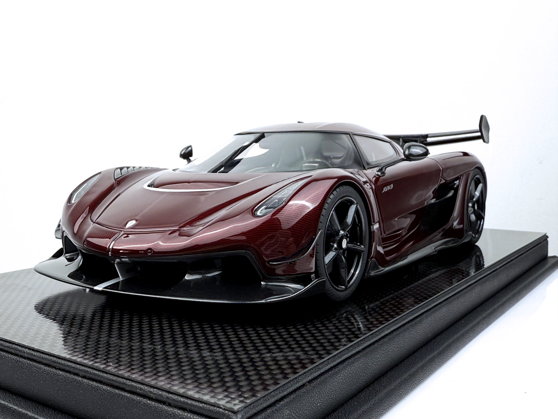 Översiktsbild av Koenigsegg Jesko Red Tinted Carbon Edition 1:18, som visar dess slanka aerodynamiska design, rödfärgade kolfiberkaross och aggressiva framtoning.