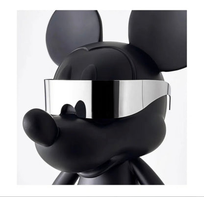 Närbild på huvudet av den svarta Mickey Mouse-figuren med släta linjer och reflekterande silvriga handskar i närheten.