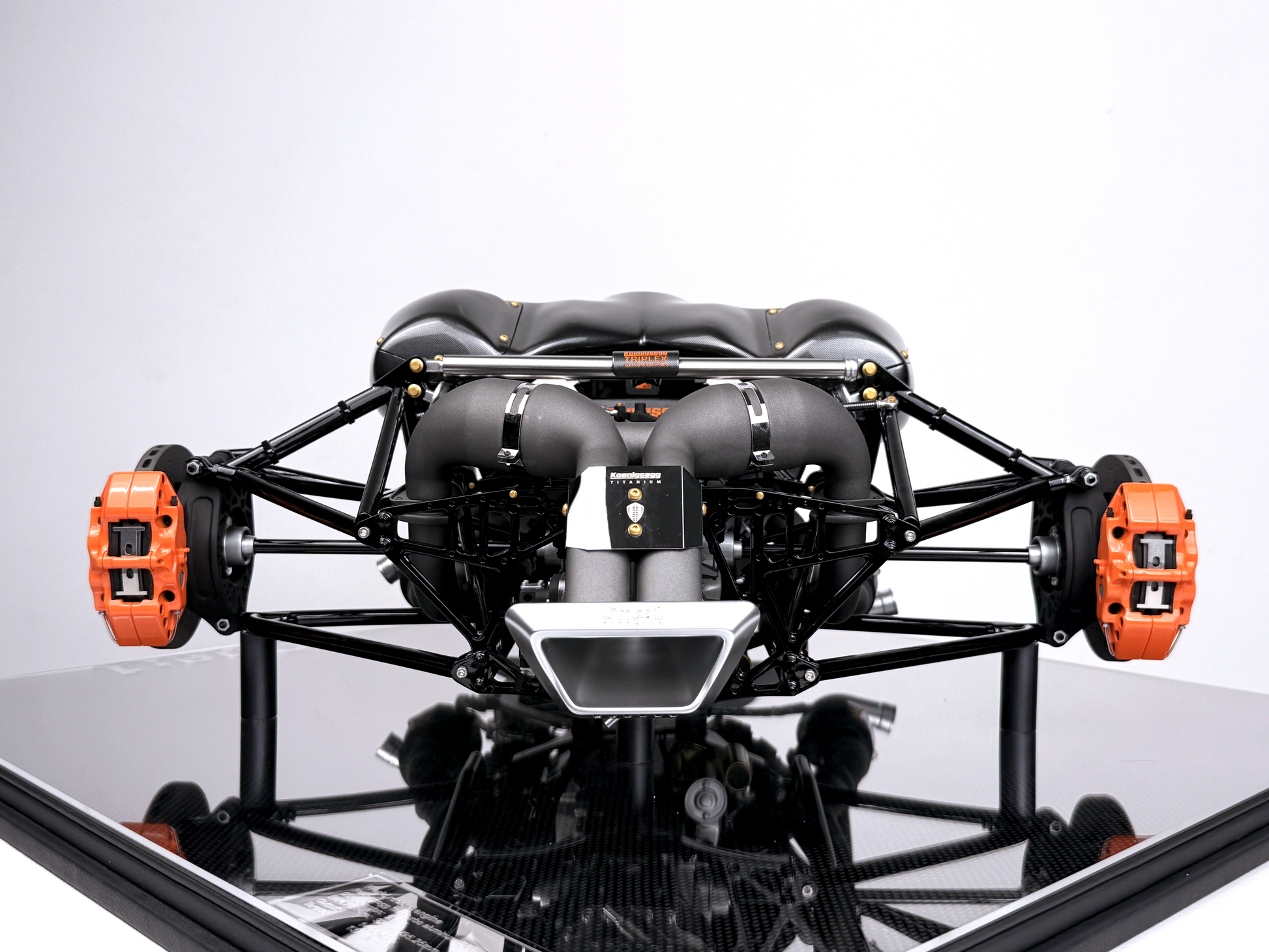Mycket detaljerad Jesko V8-motormodell i skala 1:4, placerad på en glansig display med kolfibermönster.